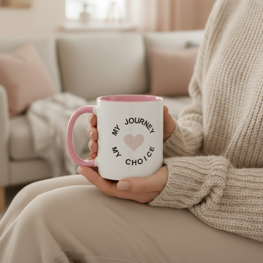 Person sitting on a sofa holding the My Journey My Choice two tone mug in a cosy living room